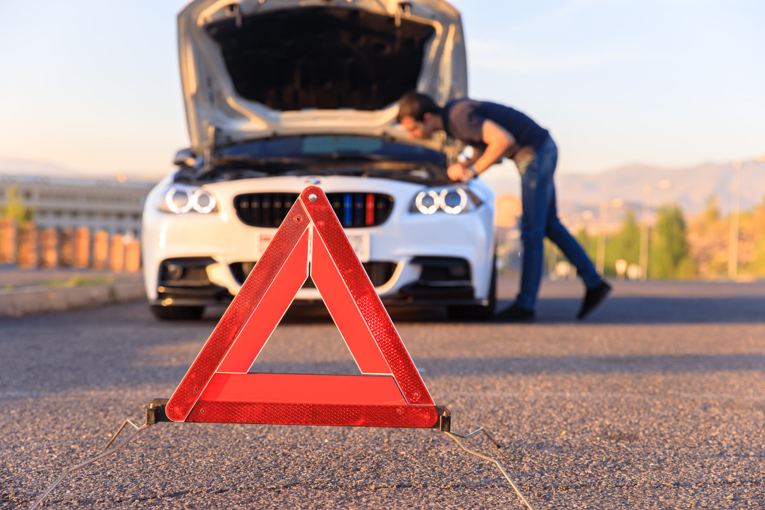 man near his broken car